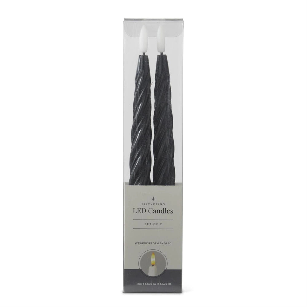A set of two black spiral flickering LED taper candles in clear packaging.