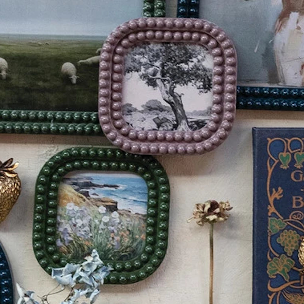 Small square bobbin-style resin photo frames in dusty pink and forest green featuring a beaded edge and nature photography.