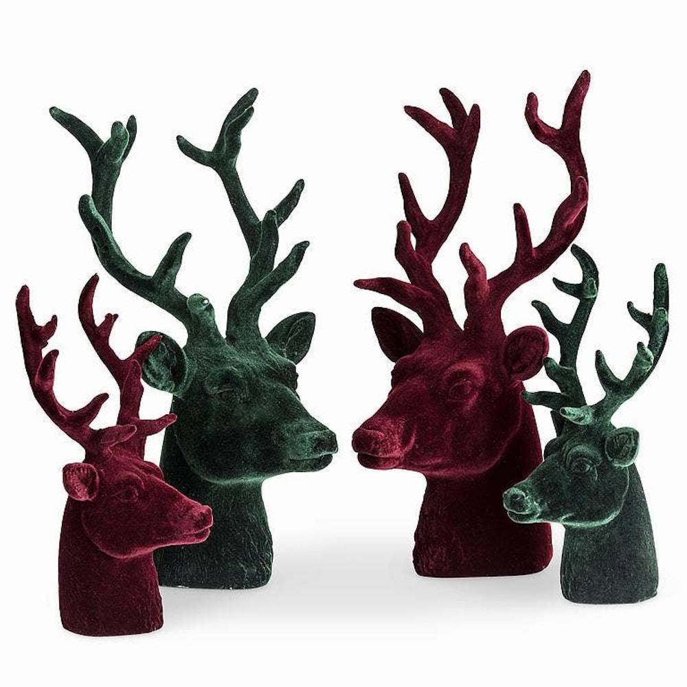 Four velvet stag head statues in green and dark red set against a plain white background.