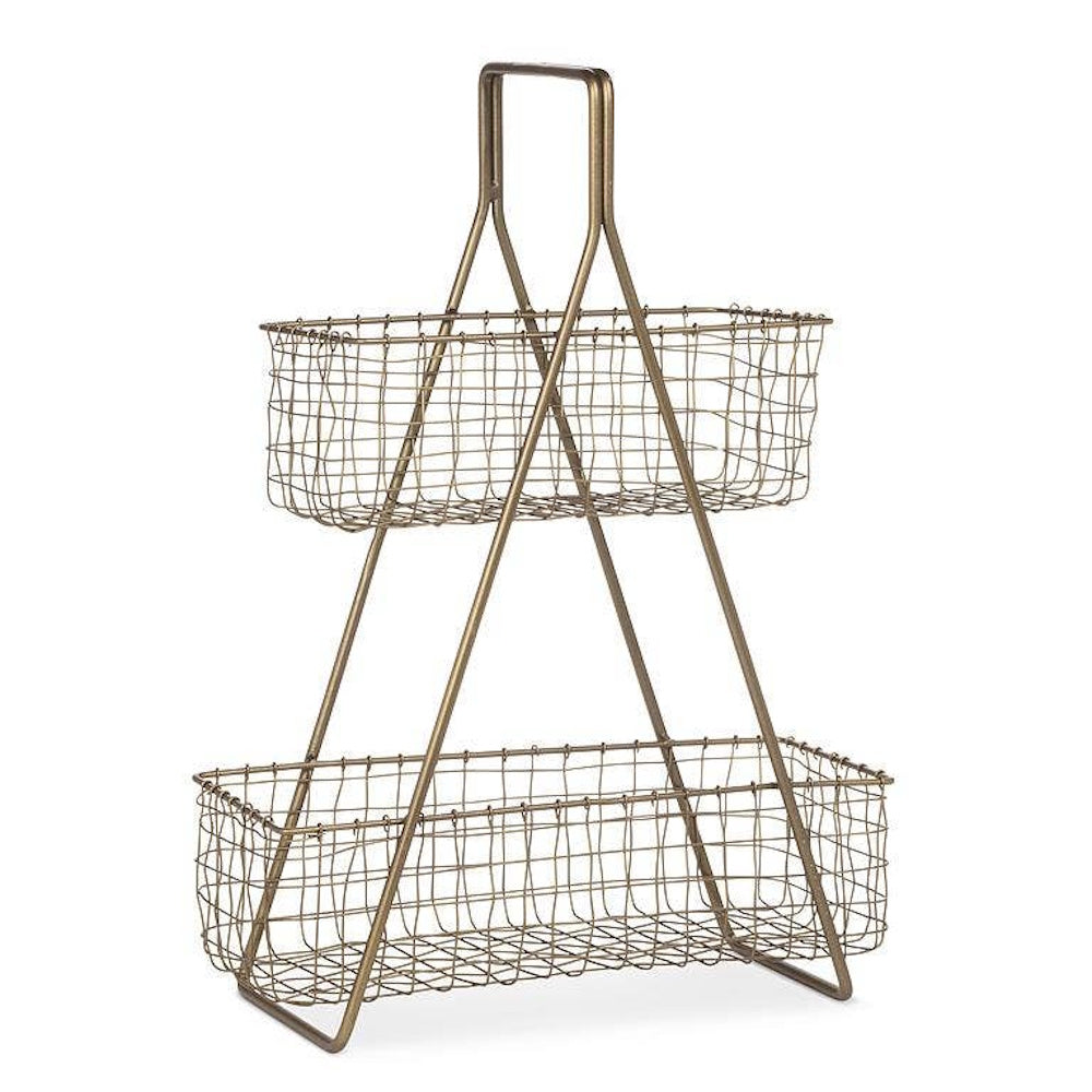 Two-tiered brass wire basket stand with a top handle on a plain white background.