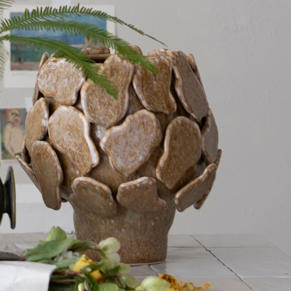 Brown stoneware footed planter covered in textured, overlapping layers of organic ceramic petals.