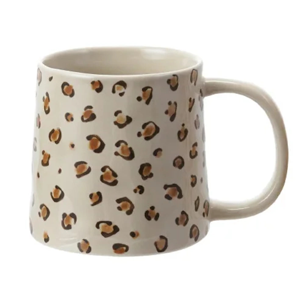White ceramic mug with brown and black leopard print pattern, large handle, and tapered shape on white background.