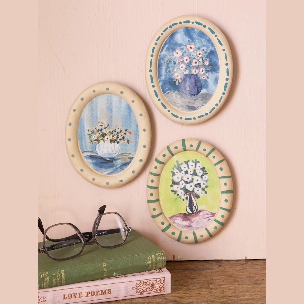 Set of 3 miniature oval floral wall art pieces with hand-painted ceramic frames and flower vase motifs.