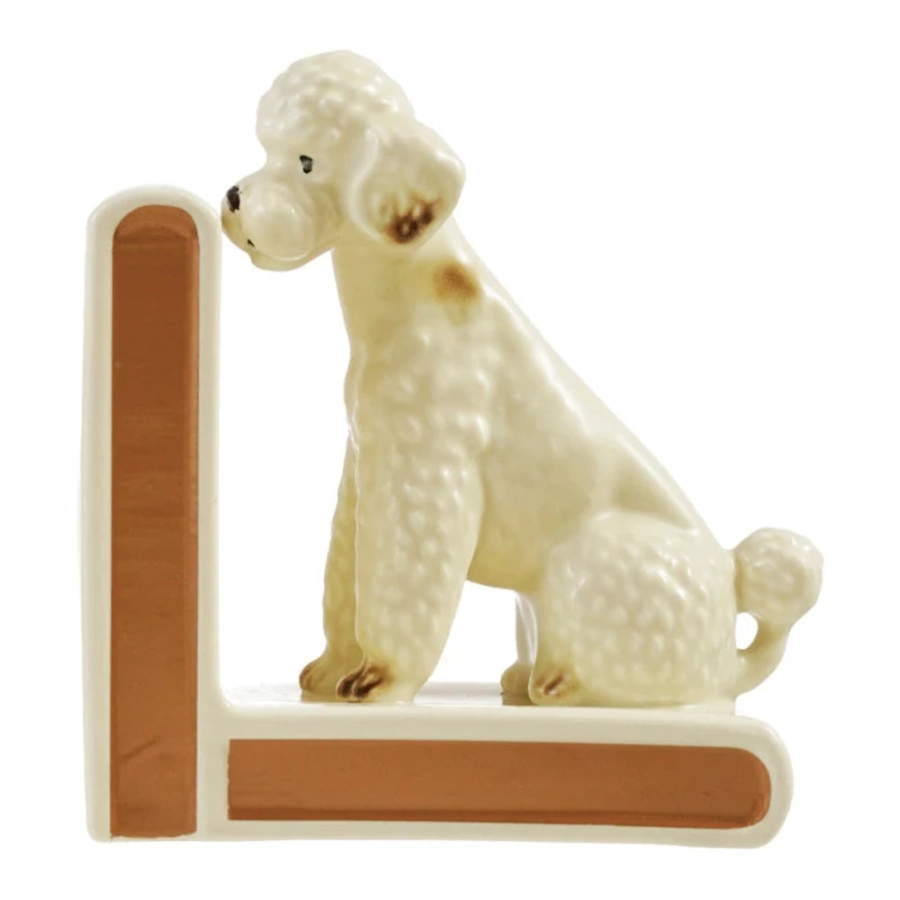 Vintage white ceramic poodle bookend with tan accents, sitting against an L-shaped base on a white background.