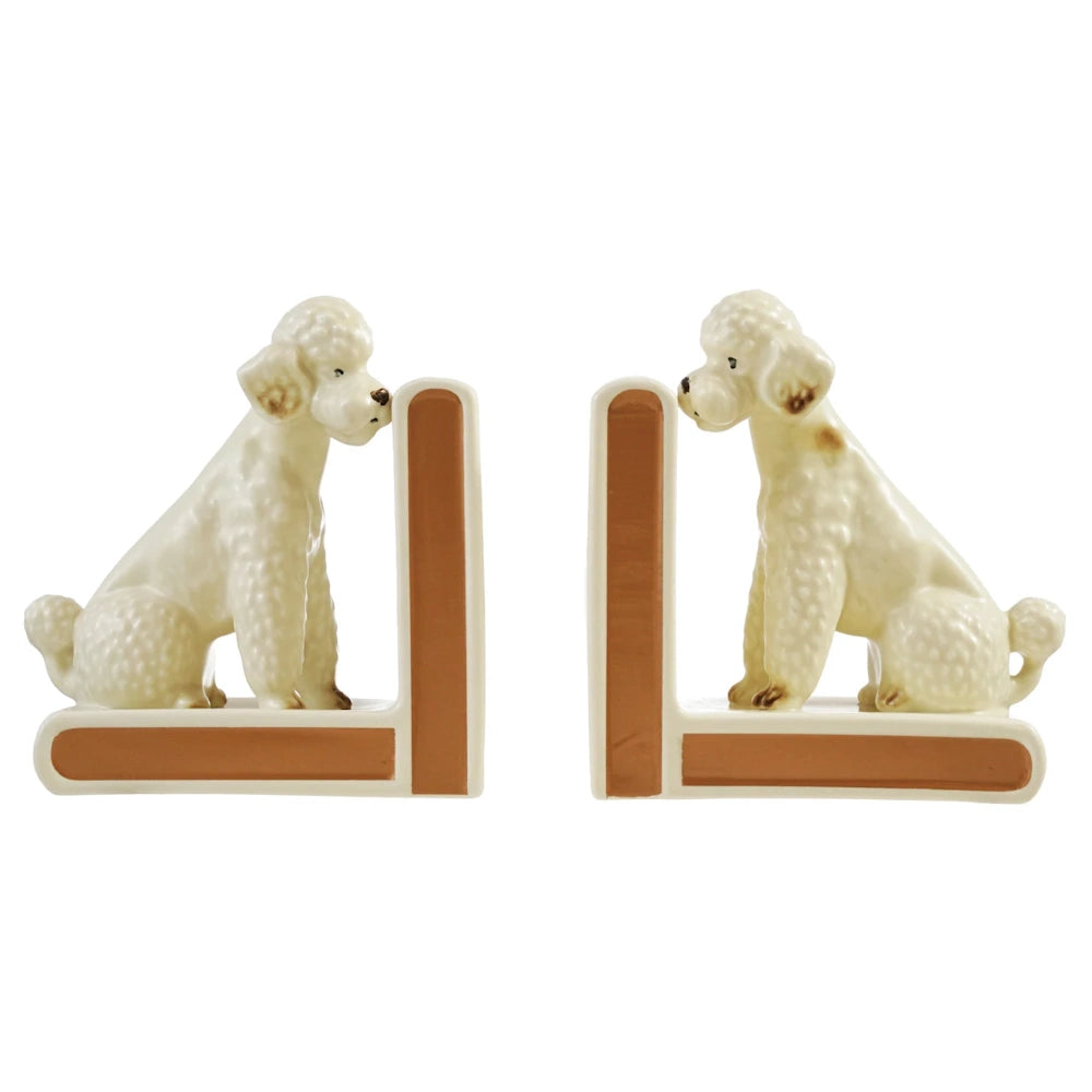 Pair of vintage white ceramic poodle bookends with brown trim, facing each other on a white background.