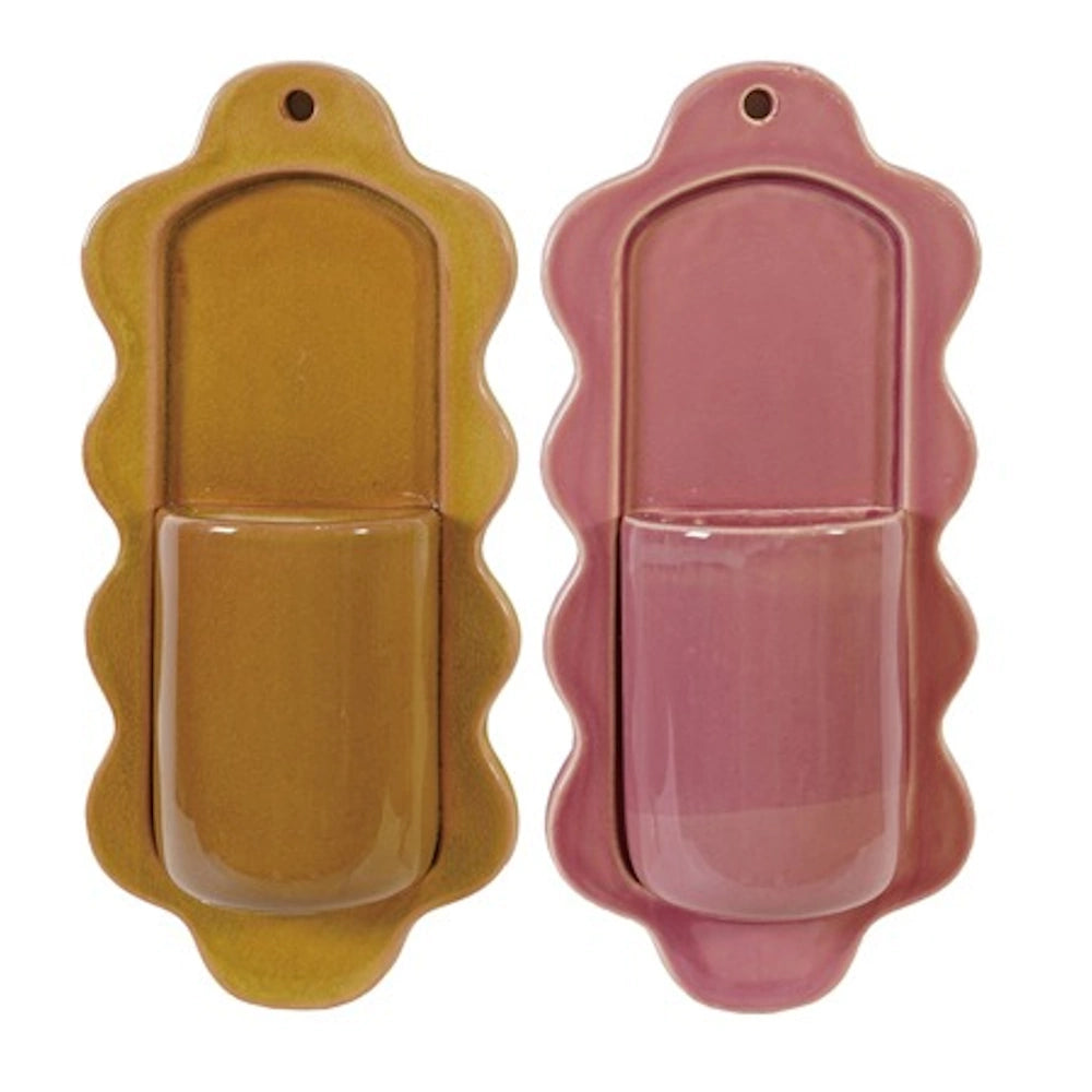 Two glazed ceramic scalloped wall vases in mustard yellow and dusty rose pink on a white background.
