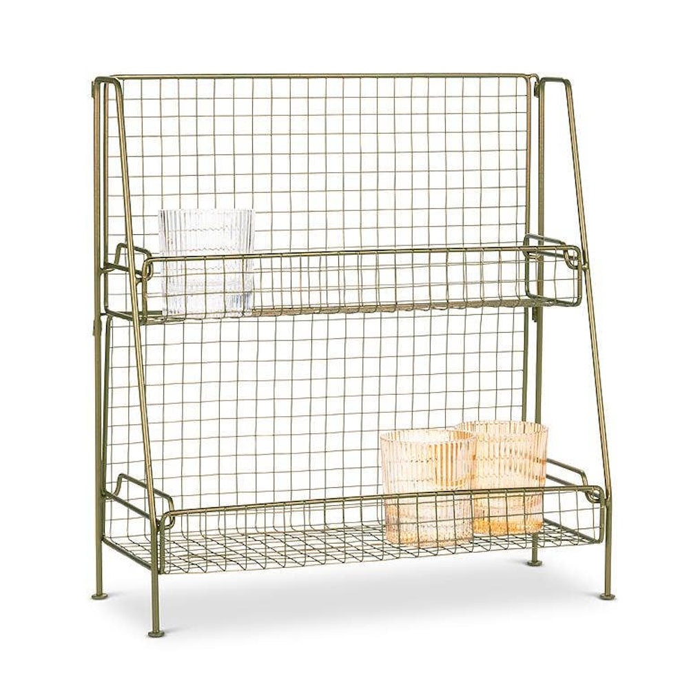 Two-tier brass wire rack holding ribbed glass cups on a white background.