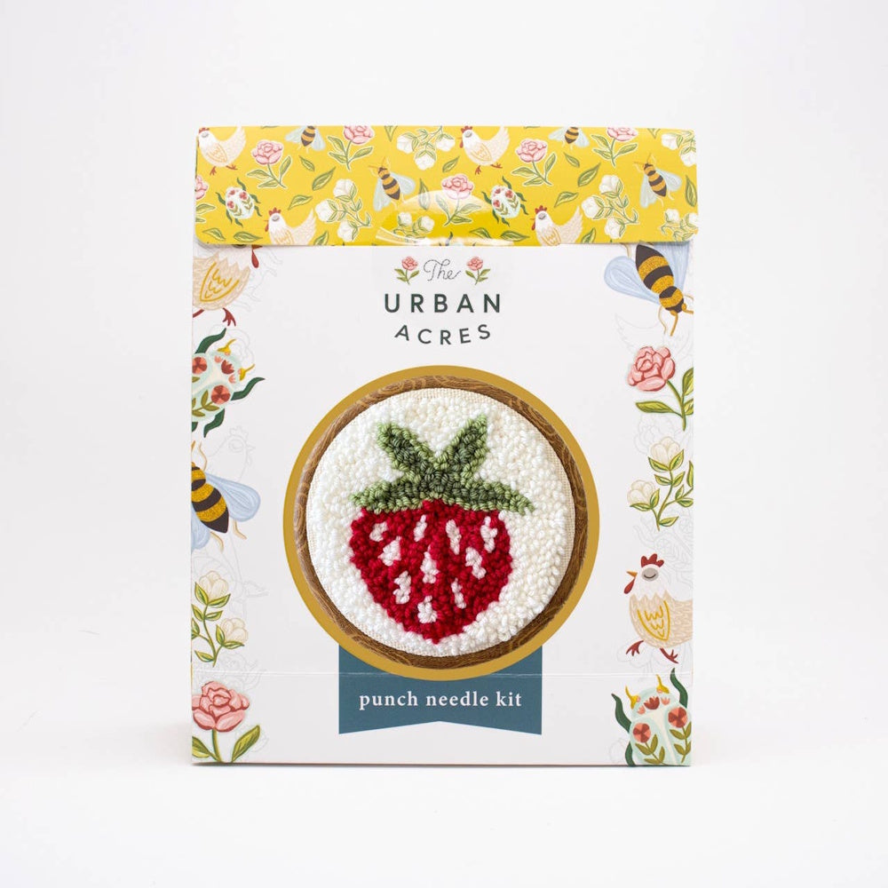 Strawberry punch needle kit packaging featuring a finished strawberry embroidery in a wooden hoop.