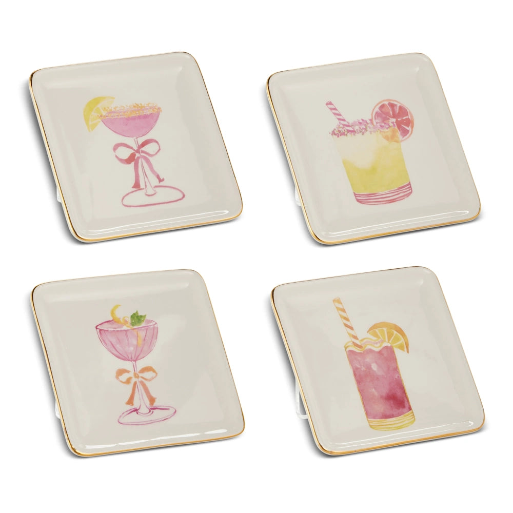 Four square white plates with gold rims, featuring colorful illustrations of cocktails with garnishes and straws, conveying a festive and elegant tone.