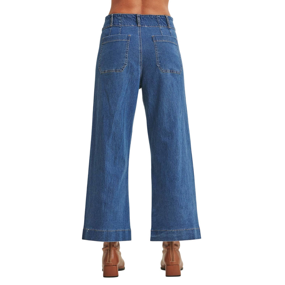 Back view of high-waisted, wide-leg medium wash blue jeans with patch pockets and brown ankle boots.