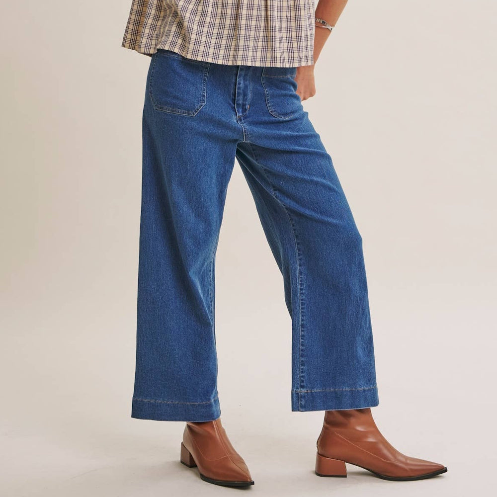 Ankle-length wide-leg blue jeans with front patch pockets styled with brown leather ankle boots.