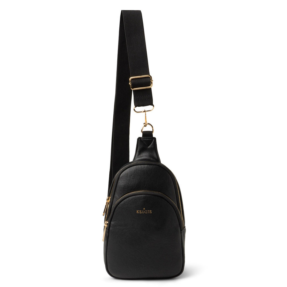 Black Kedzie sling bag with gold zippers and a thick adjustable strap, isolated on a white background.