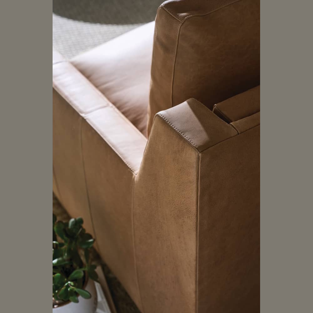 Close-up of a tan leather recliner chair showing high-quality stitching and texture for modern home decor.