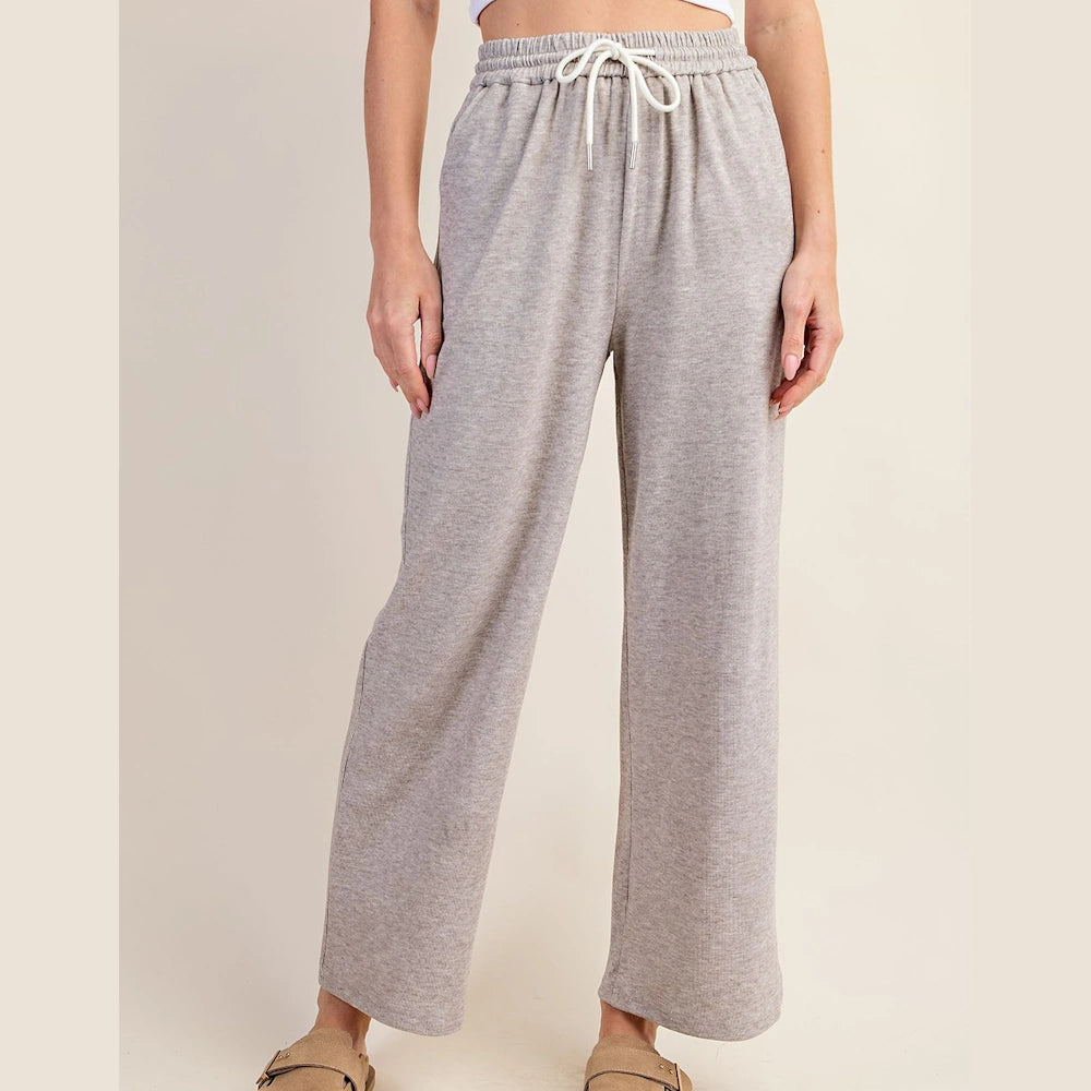 Taupe wide-leg knit pants with a white drawstring elastic waistband and a relaxed fit.