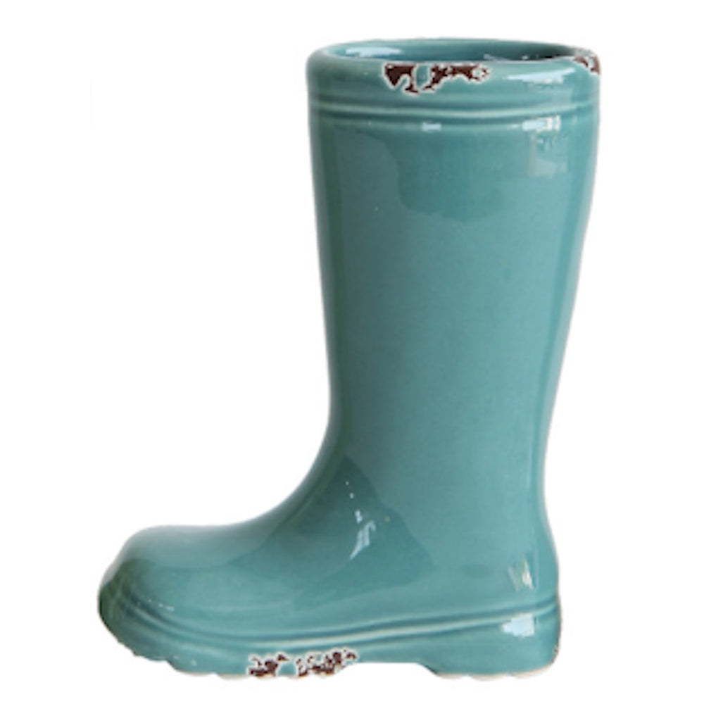 A teal ceramic vase shaped like a rain boot with a glossy glaze and faux-distressed brown spots on the edges.