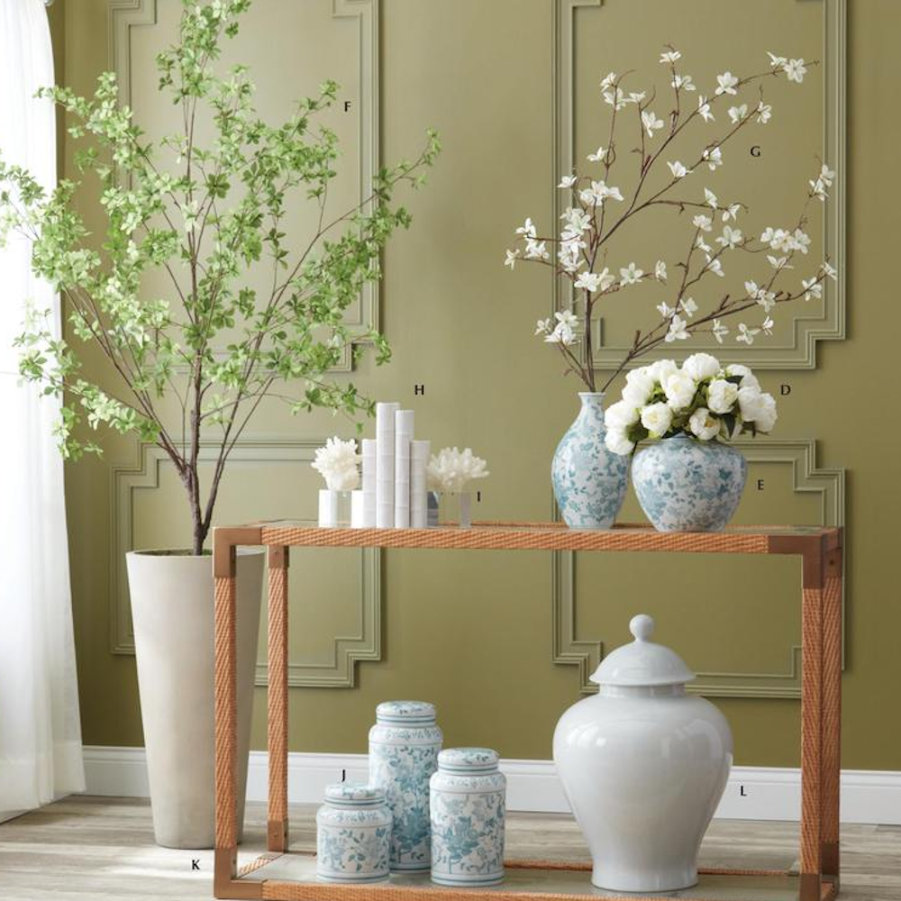 Teal and white porcelain chinoiserie ginger jars on a wooden console table against an olive green wall with molding.