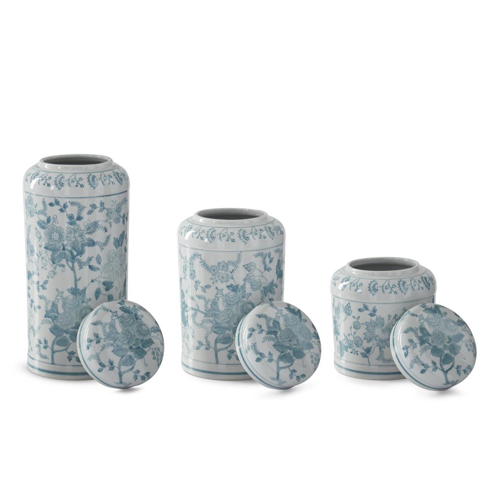 Teal and white Chinoiserie porcelain jars in three sizes with floral patterns and matching lids on a white background.