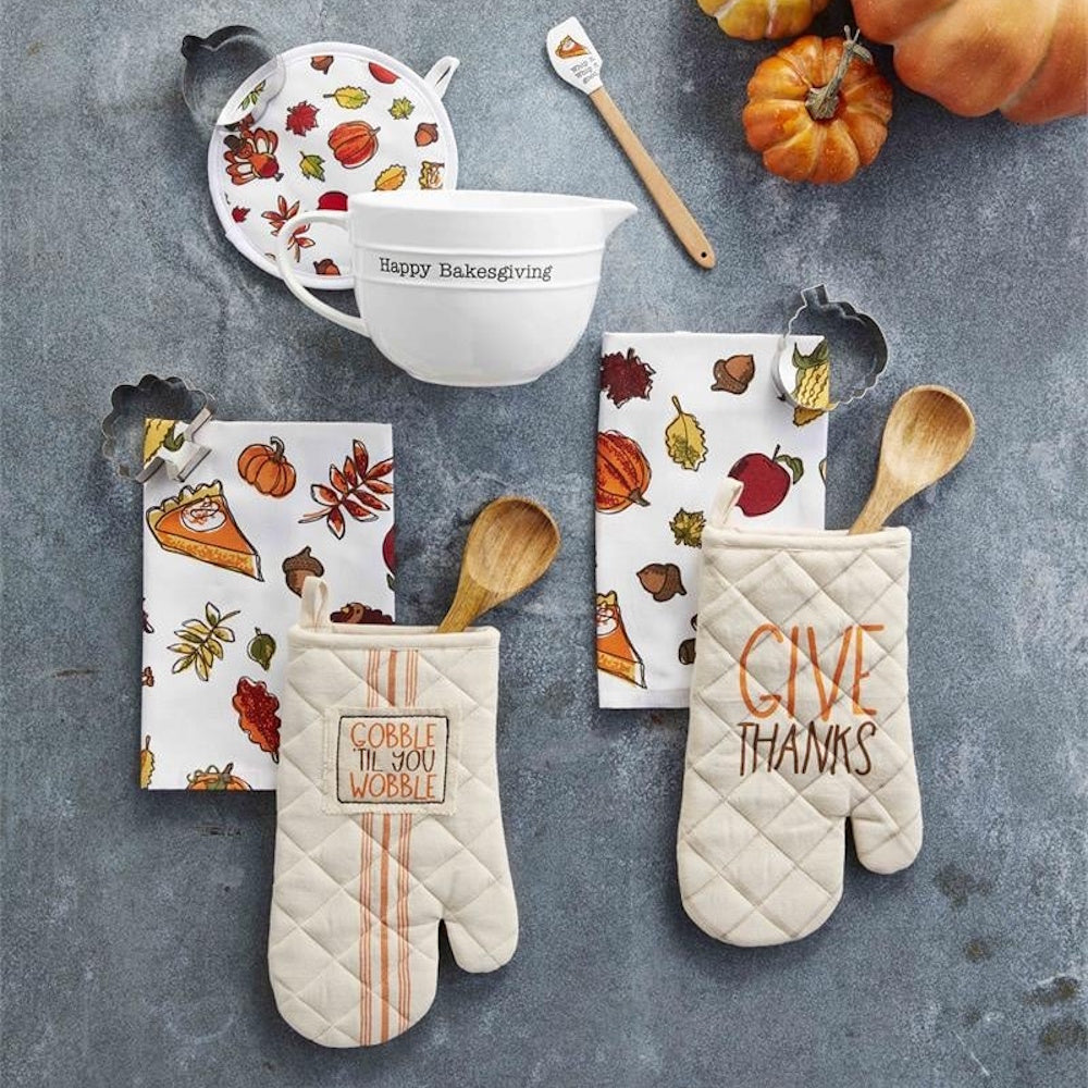 Thanksgiving baking set with mixing bowl, oven mitts, printed towels, and wooden utensils.