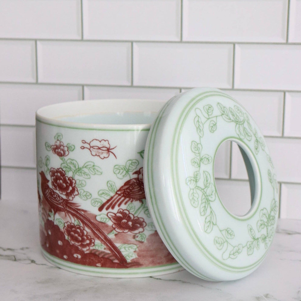 Porcelain tissue vessel with red floral and bird pattern, shown open with its matching patterned lid.
