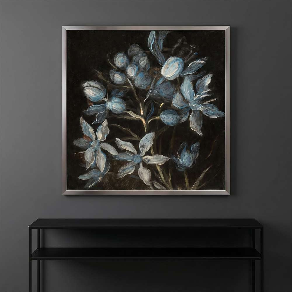 Dark framed floral art print hung above a sleek black console table against a moody dark grey wall.