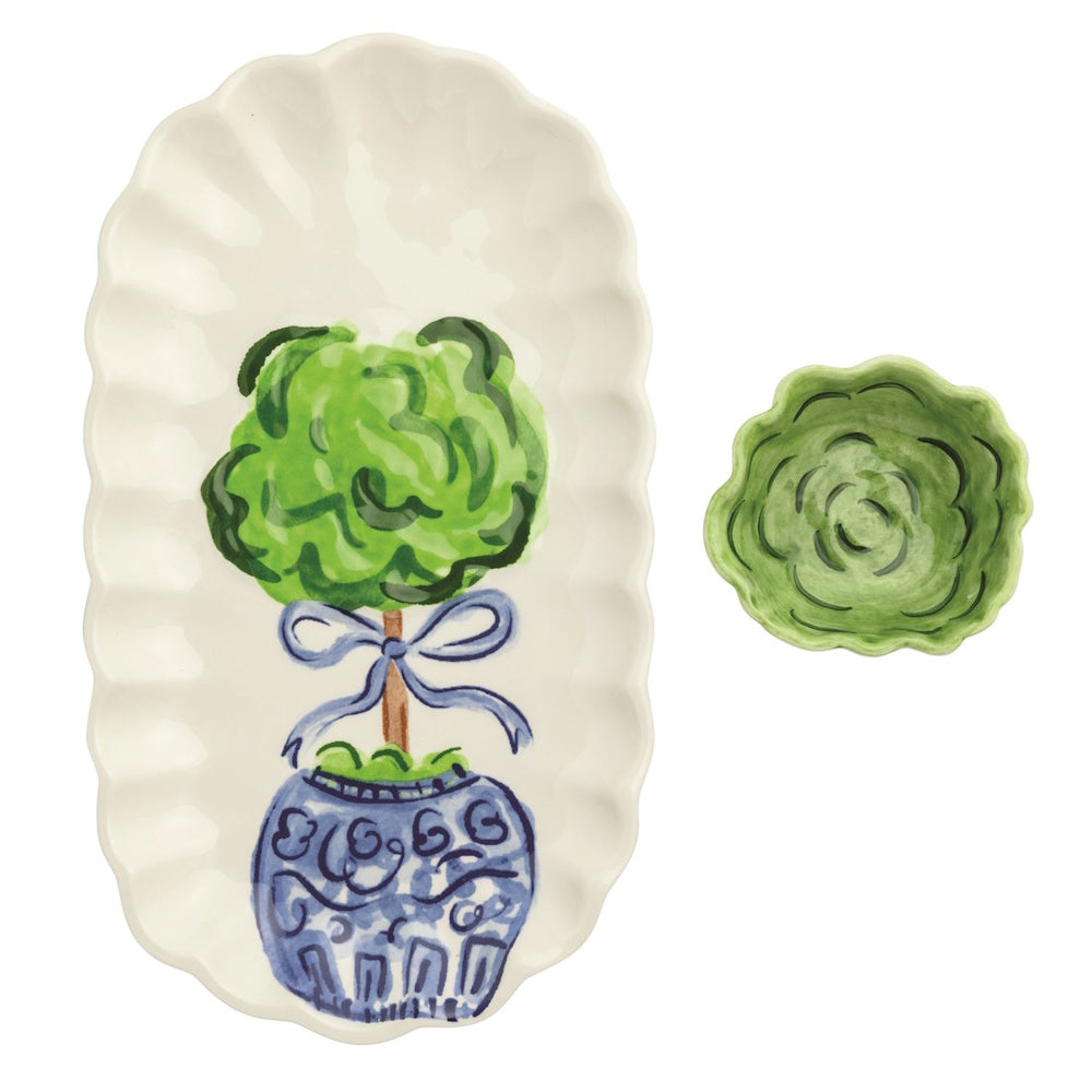 Two-piece ceramic set featuring a scalloped white oval tray with a painted topiary and a small green tidbit bowl.