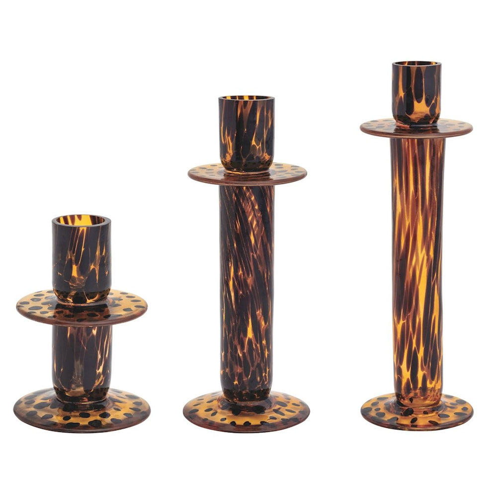 Set of three tortoise shell glass candlesticks in varying heights with amber and dark brown speckled patterns.
