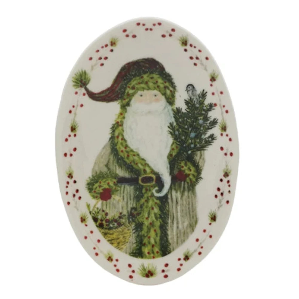 An oval white platter featuring Santa holding a small evergreen tree with a bird perched inside.