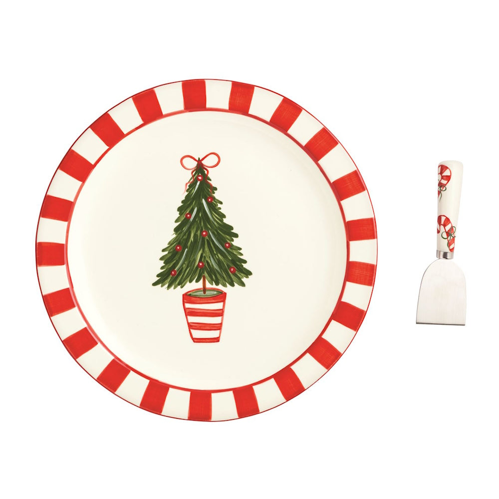 Round Christmas plate with a striped rim, potted tree art, and matching candy cane serving spatula.