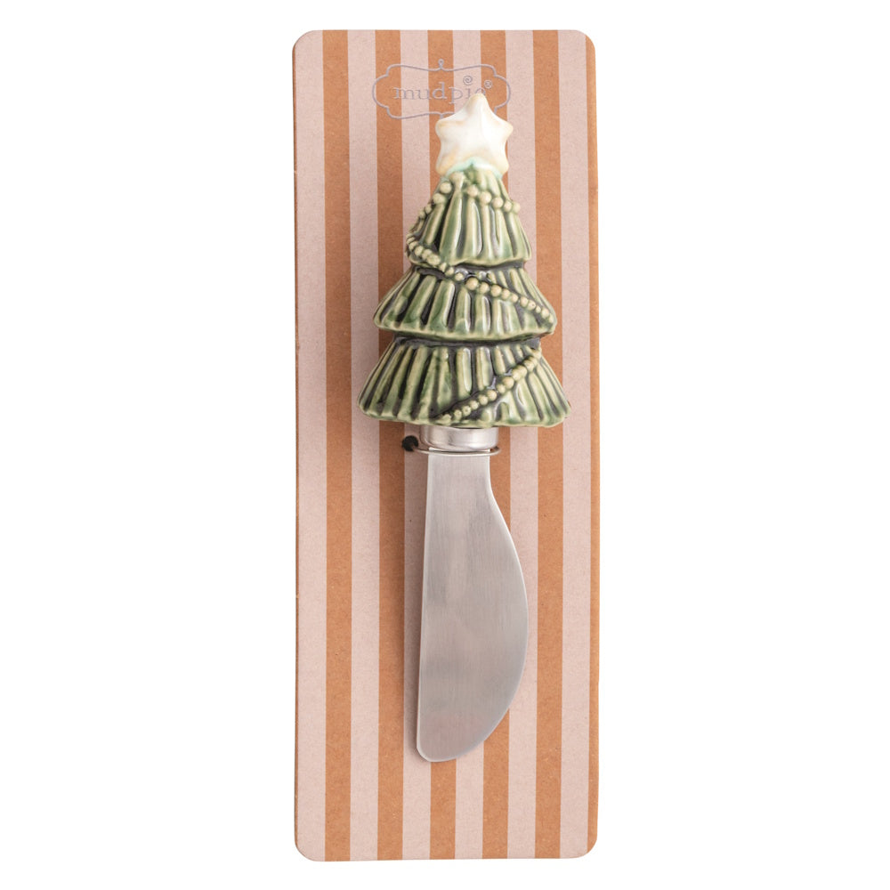 Green Christmas tree figural spreader with a star topper on striped packaging.