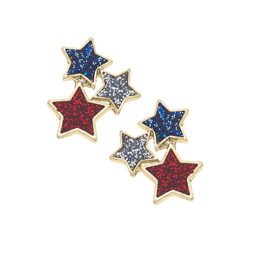 Two pairs of gold-trimmed star stud earrings featuring red, silver, and blue glitter-filled celestial shapes.