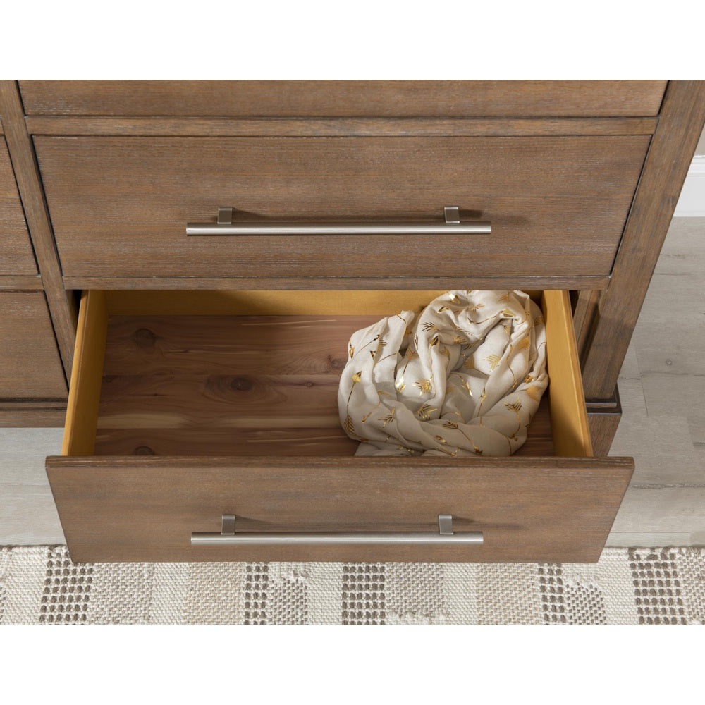 Open wooden dresser drawer showing a cedar-lined bottom with a folded white scarf inside.