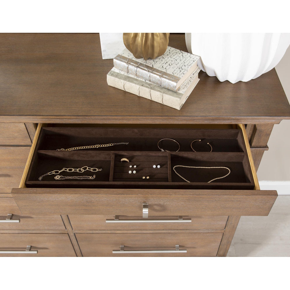 Open wooden dresser drawer featuring a dark brown velvet-lined jewelry organizer with gold accessories.