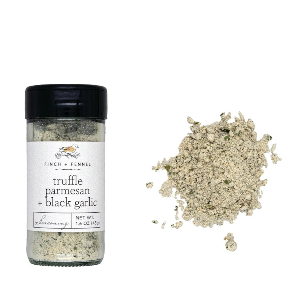 A jar of Finch + Fennel Truffle Parmesan + Black Garlic Seasoning next to a small pile of the seasoning blend.