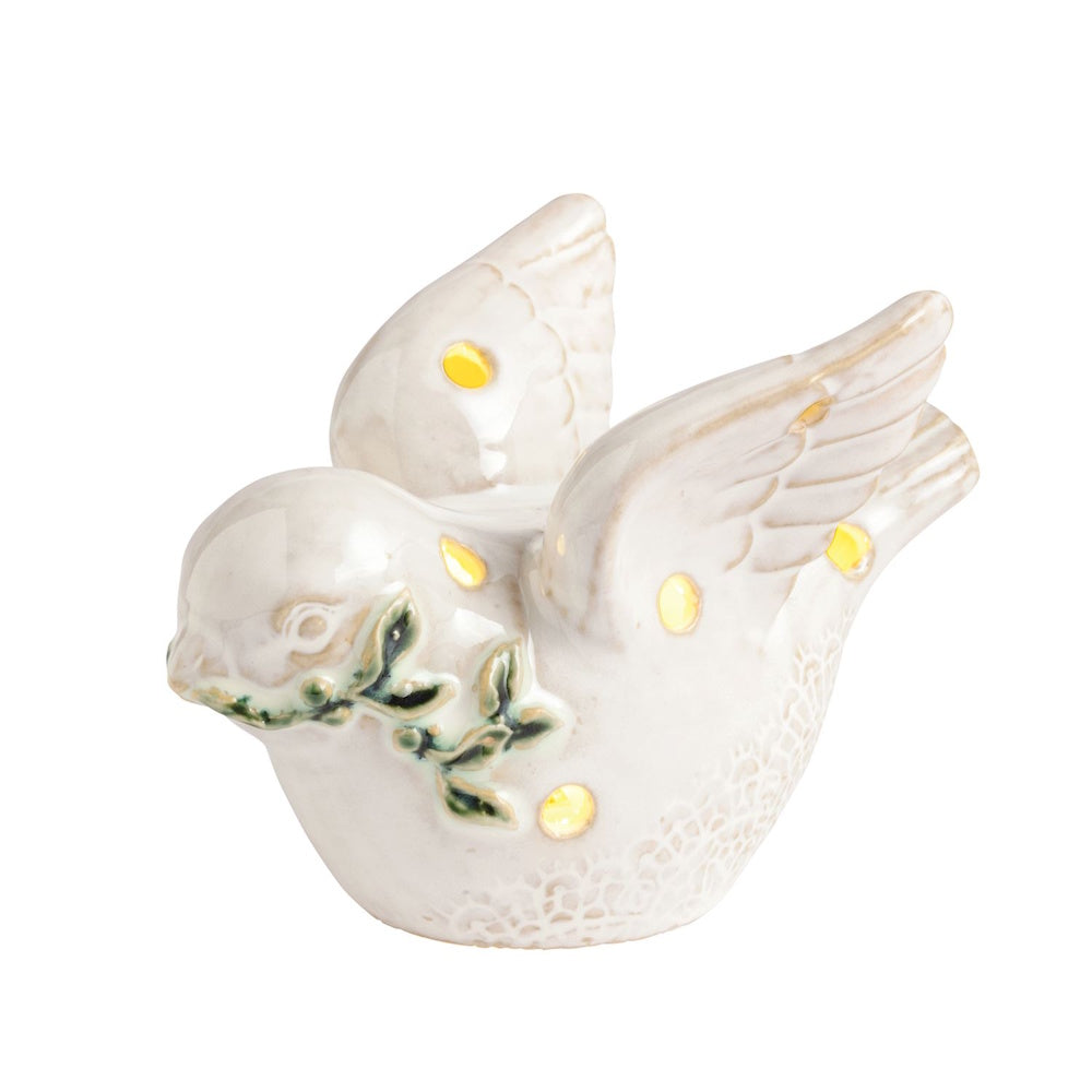 White ceramic light-up dove figurine holding a green leafy branch with warm glowing cutouts.