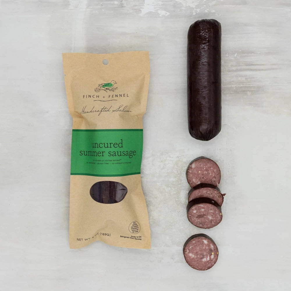 Finch + Fennel uncured summer sausage package beside a whole sausage link and several thick, round slices.