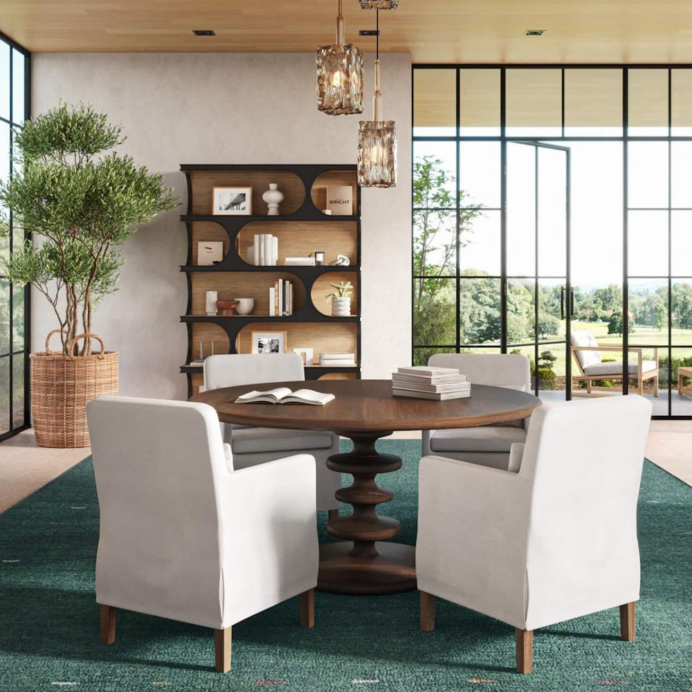 Vannes Crescent Bookcase behind a wooden dining table with four white upholstered chairs.