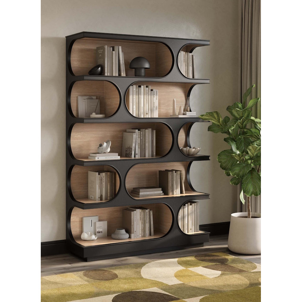 Modern black Vannes crescent bookcase with wood shelves and books next to a fiddle-leaf fig plant.