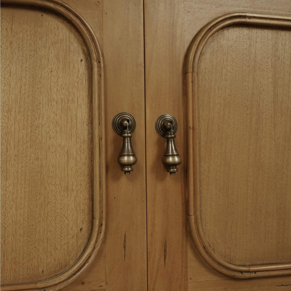 Close-up of Victoria wooden bookcase doors with antique brass drop handles.