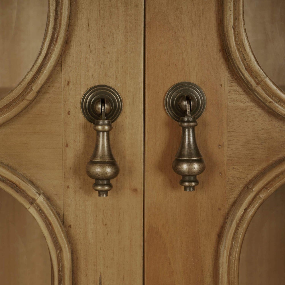Antique brass drop pull handles on the glass doors of a Victoria oak wood bookcase.