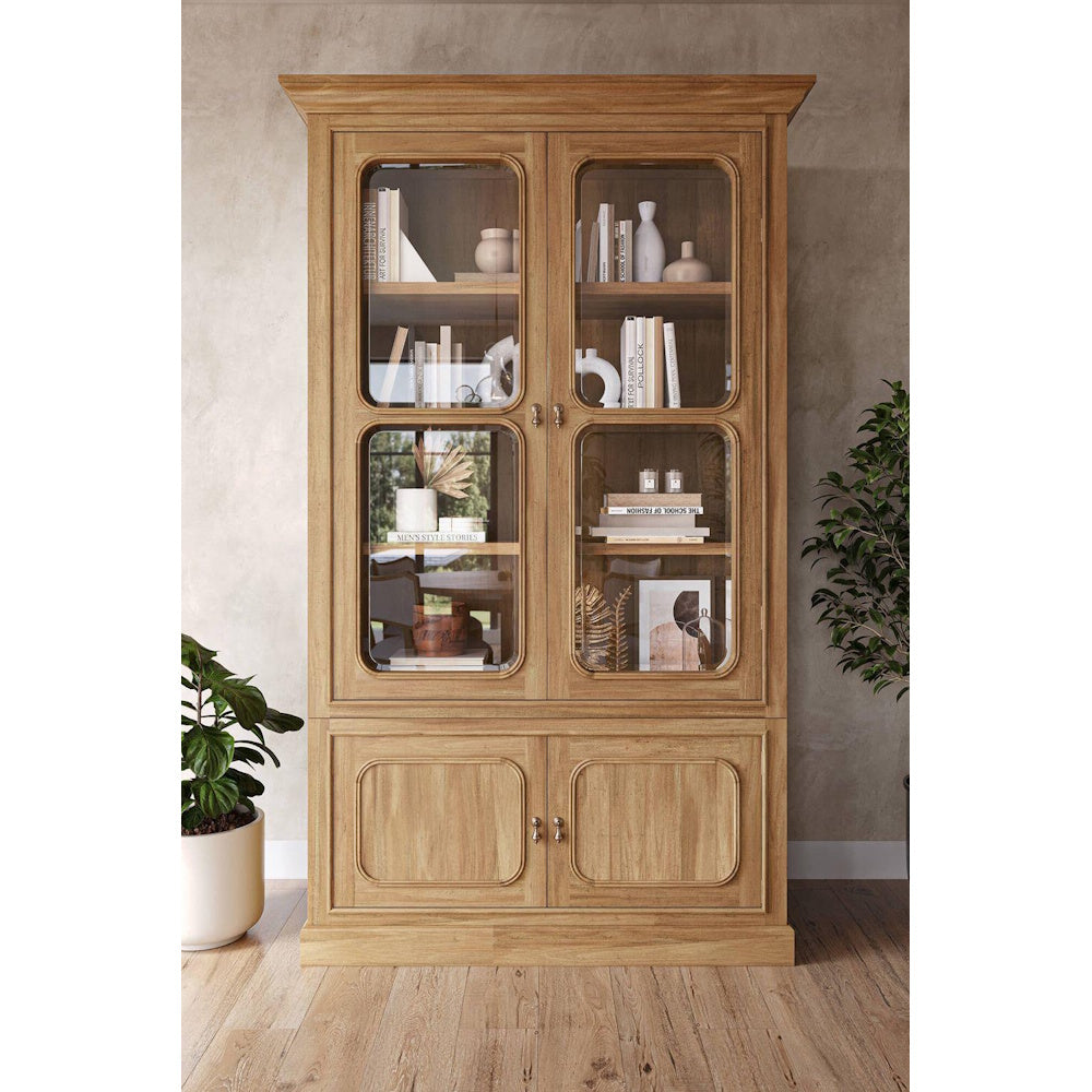 Victoria wooden bookcase with glass doors styled with books and decor in a living room.
