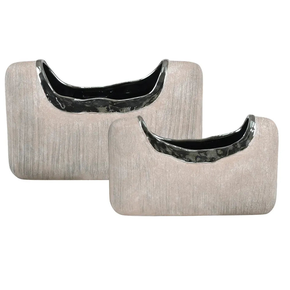 Two modern textured beige ceramic vases with curved metallic silver rims and dark interiors on a white background.