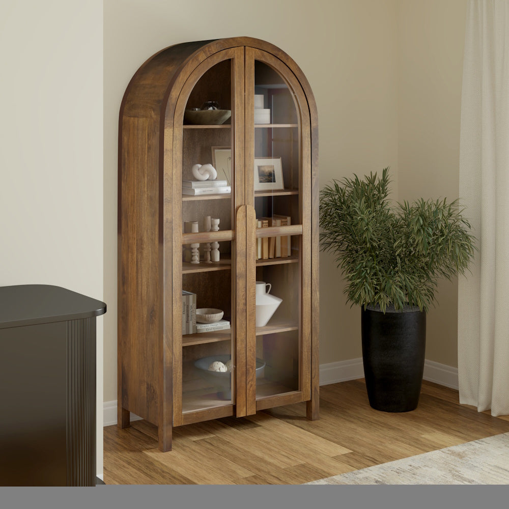 Arched wood display cabinet with glass doors and shelves, featuring a warm walnut finish and modern decor.