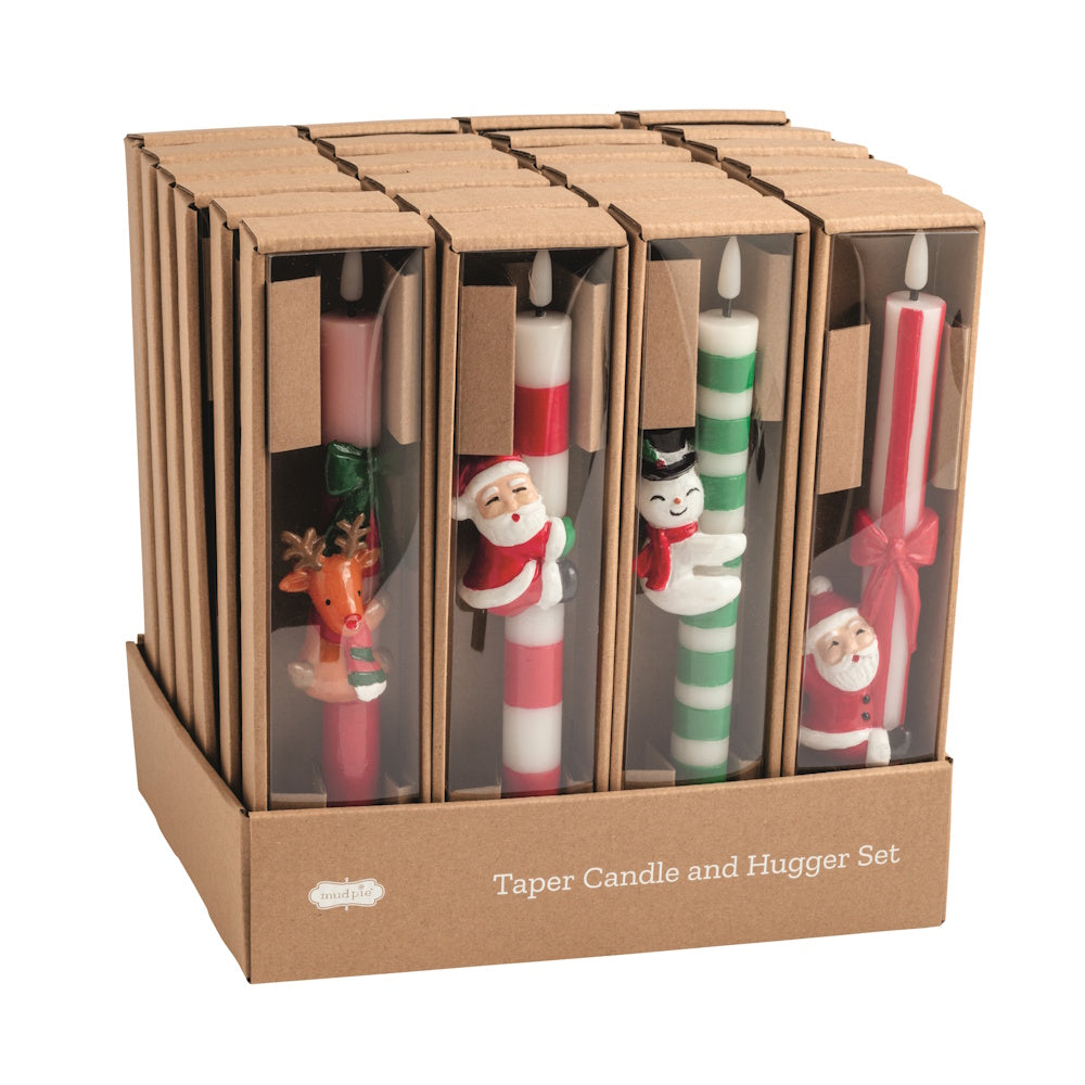 Front view of a retail display box containing multiple assorted taper candle and hugger sets by Mud Pie.