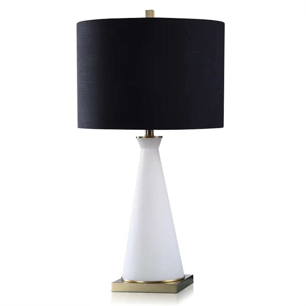 Modern table lamp with a white tapered glass base, antique brass accents, and a textured black drum shade.