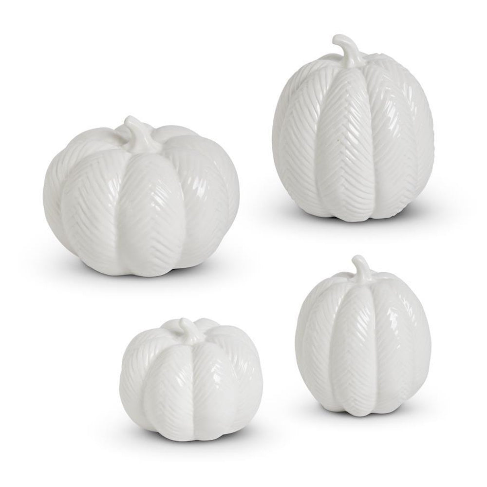 Set of four white ceramic pumpkins with embossed chevron patterns in varying shapes and sizes.