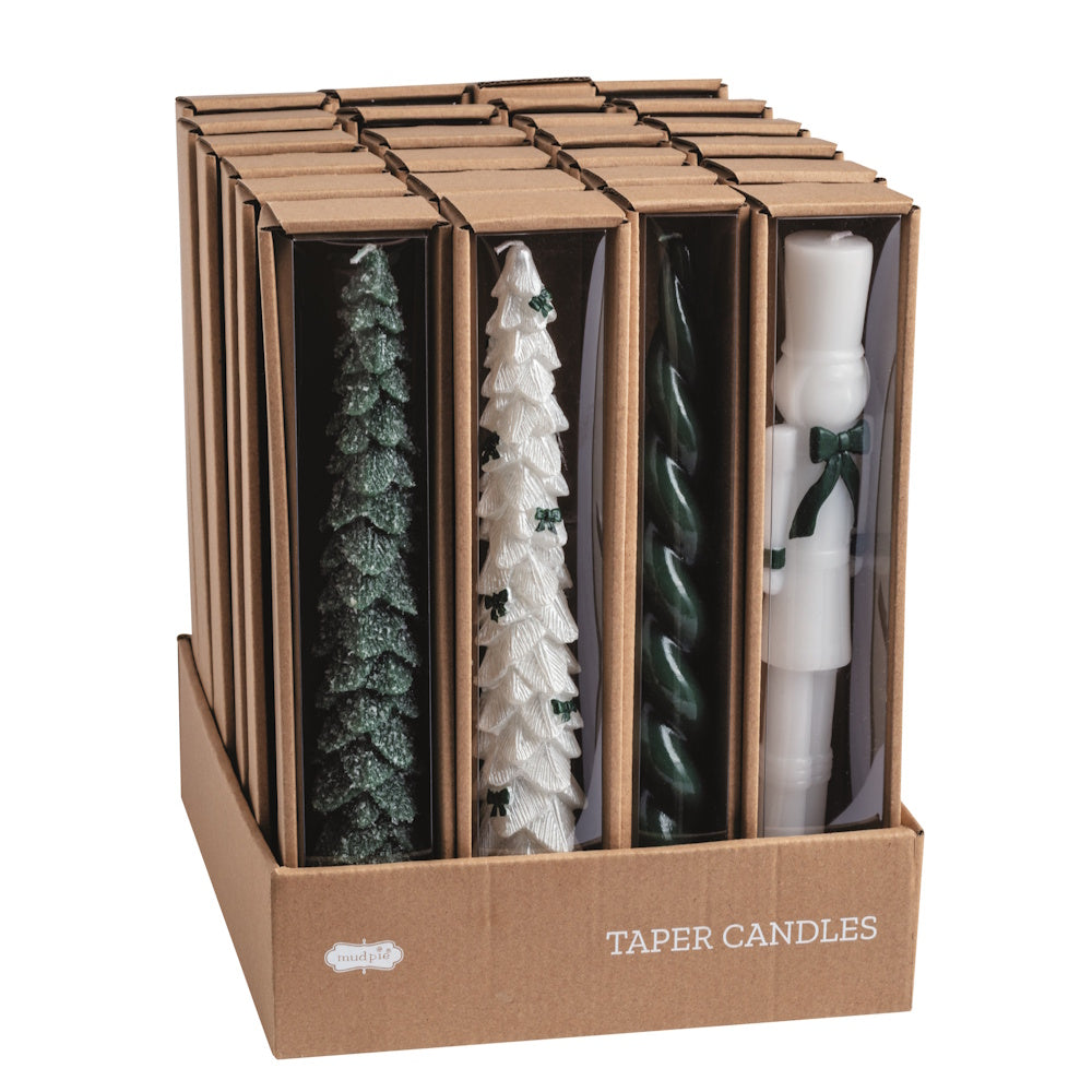 Assorted Christmas wax taper candles in cardboard packaging displayed in a retail box, angled view.