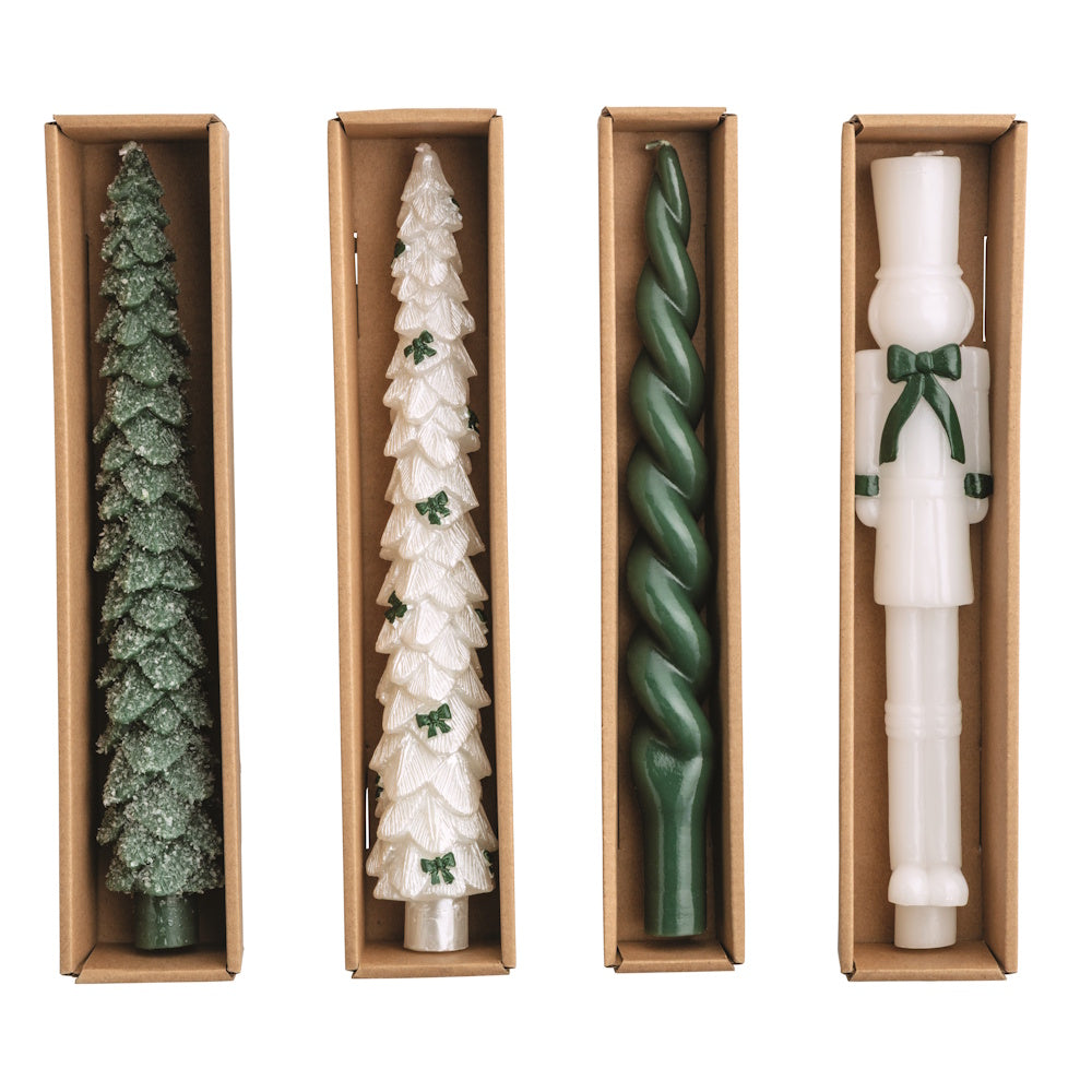 Four assorted Christmas wax candles in cardboard boxes, viewed from above.