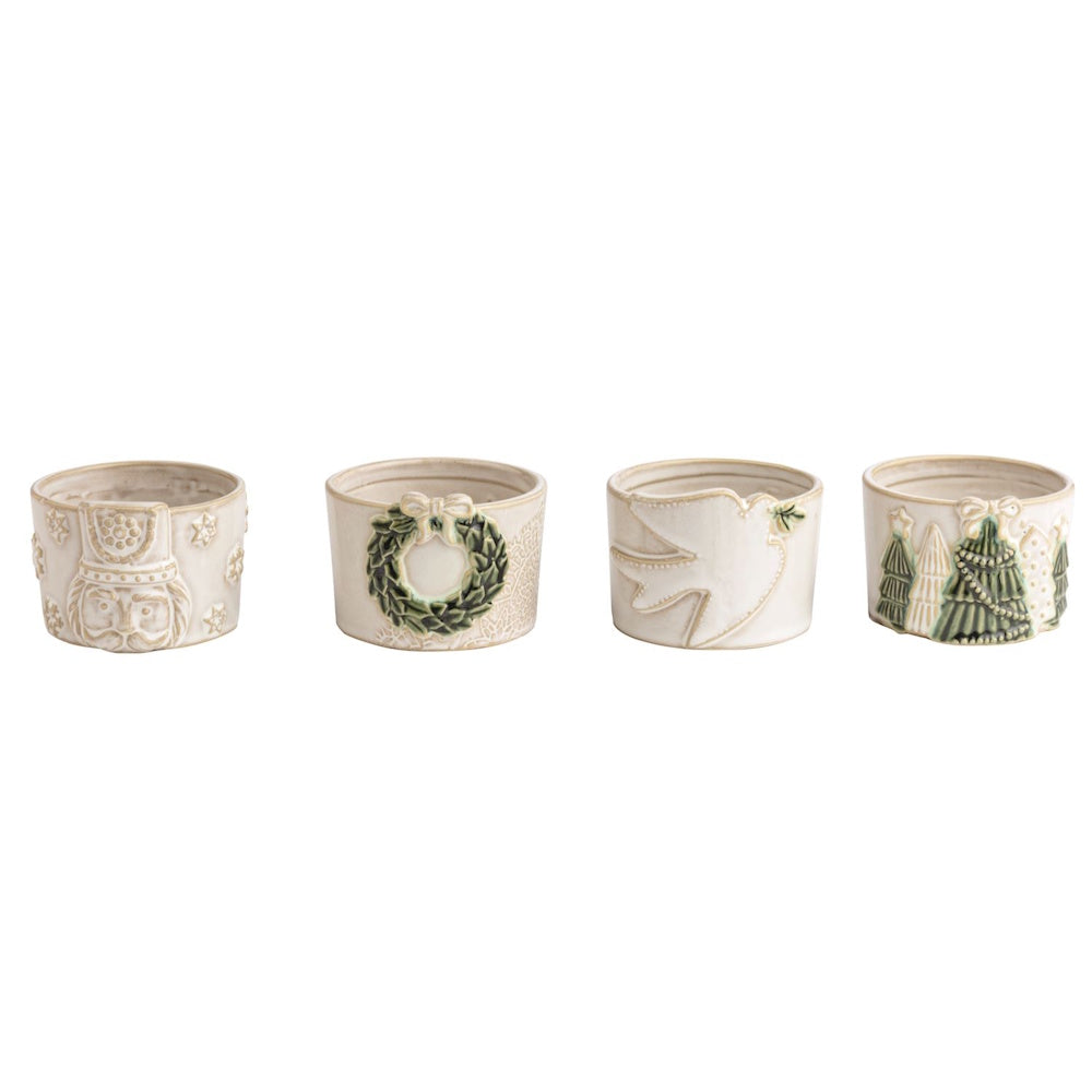 Set of 4 white ceramic dishes with embossed Christmas motifs: nutcracker, wreath, dove, and trees.