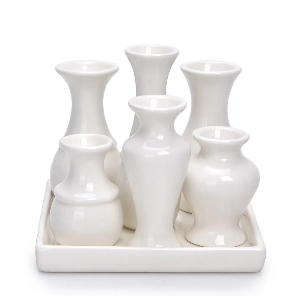 Front-facing view of a white ceramic bud vase set featuring six assorted vases on a matching tray.