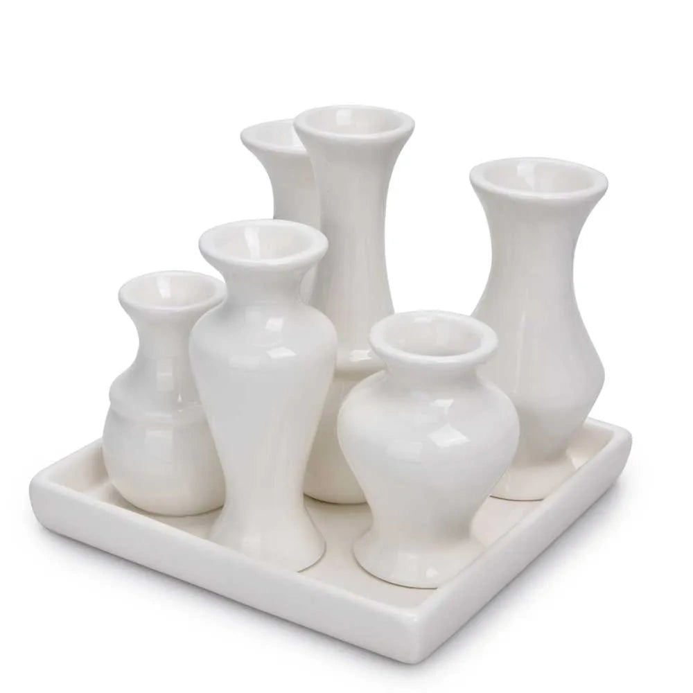 Front view of a white ceramic bud vase set with six assorted vases on a square tray.